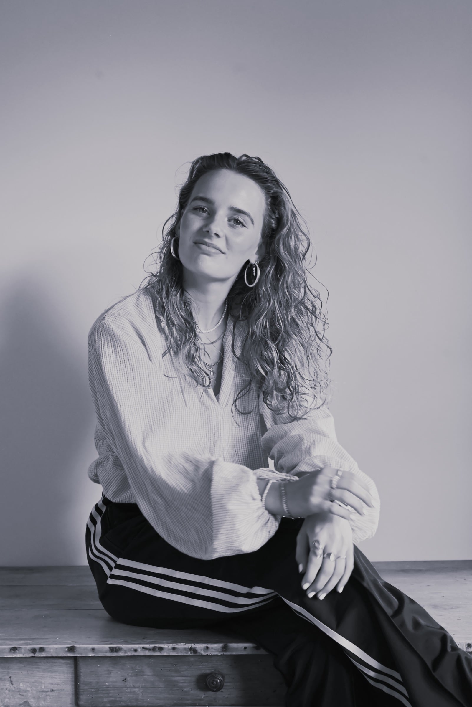 Suzie Visscher zittend op een houten bank